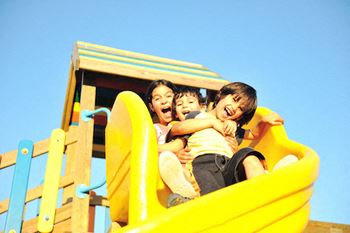 Children sliding down a slide together